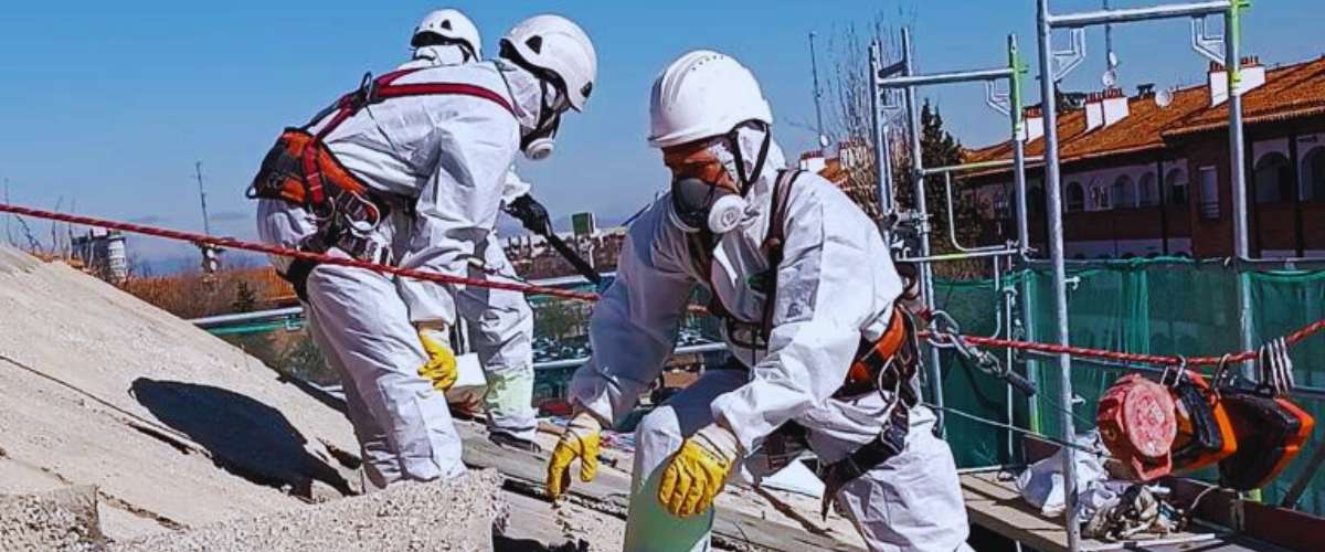 Operario con equipo de protección individual (EPI) retirando amianto